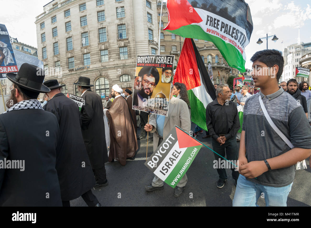La linea di anti-sionista Neturei Karta ebrei e musulmani chierici, a fronte di Al Quds giorno marzo è stata seguita da persone che trasportano i cartelli e bandiere. Foto Stock
