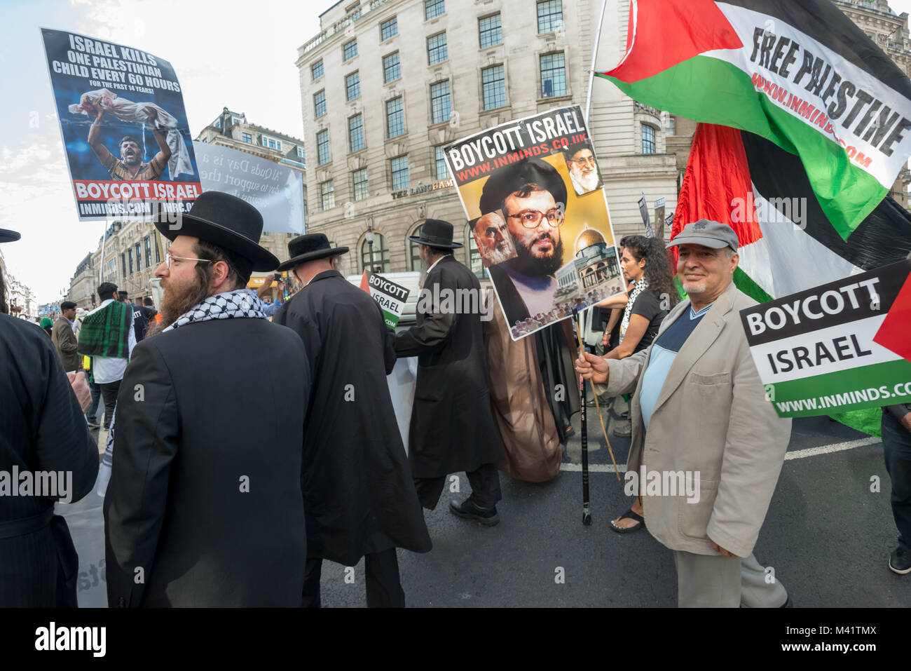 La linea di anti-sionista Neturei Karta ebrei e musulmani chierici, a fronte di Al Quds giorno marzo è stata seguita da persone che trasportano i cartelli e bandiere. Foto Stock