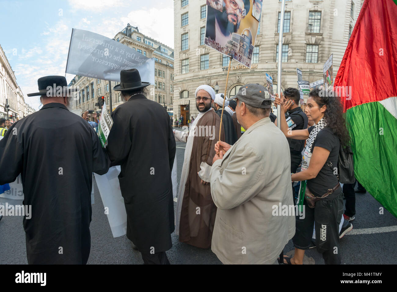 La linea di anti-sionista Neturei Karta ebrei e musulmani chierici, a fronte di Al Quds giorno marzo è stata seguita da persone che trasportano i cartelli e bandiere. Foto Stock