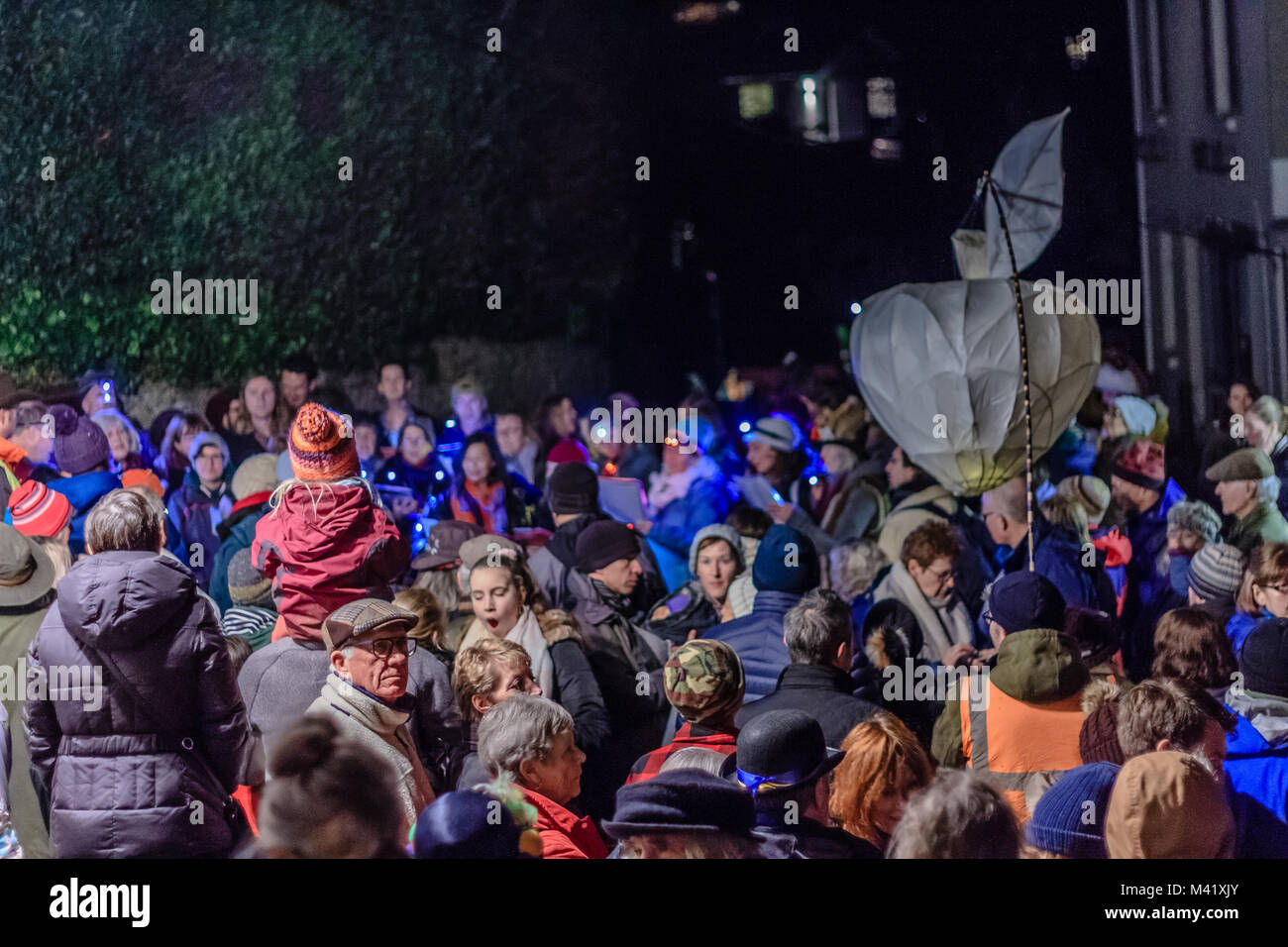A forma di mela lanterna di carta portati dalla folla attraverso la strada a un wassail o tradizionale winter festival apple, Stoke Gabriel, Devon, Regno Unito. Jan 2018. Foto Stock