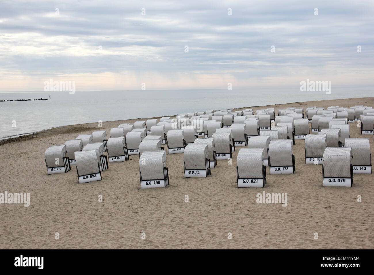 Le sedie a sdraio sulla spiaggia con il mare del Nord sono in attesa per i visitatori. O la pioggia arriva per primo? Foto Stock