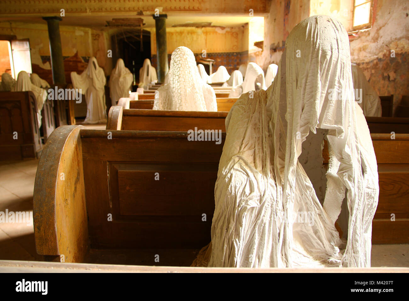 La foto dall'interno del vecchio abbandonato, quasi distrutta chiesa nella Repubblica Ceca. All'interno sono le statue dei credenti fantasmi. Foto Stock
