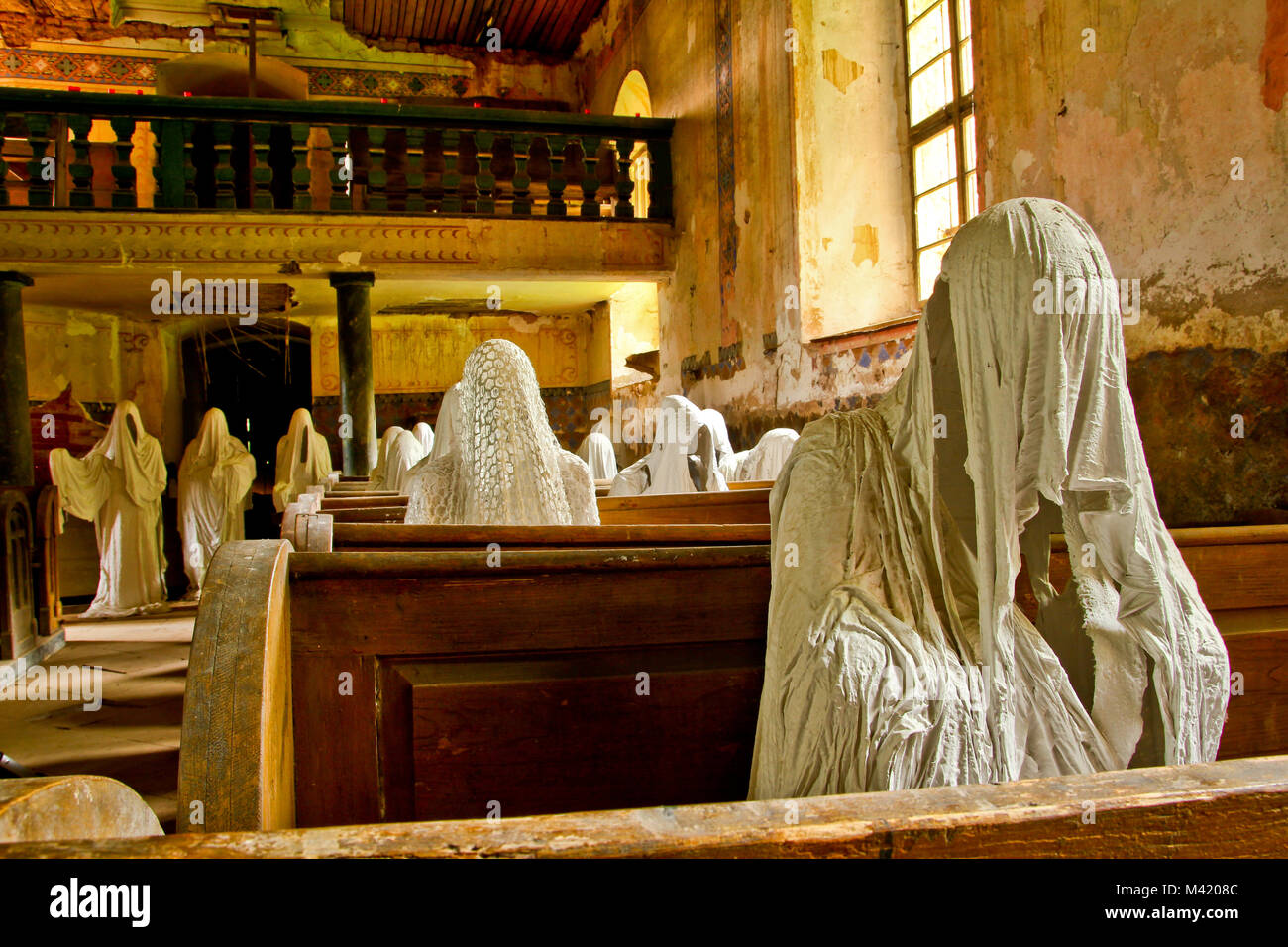 La foto dall'interno del vecchio abbandonato, quasi distrutta chiesa nella Repubblica Ceca. All'interno sono le statue dei credenti fantasmi. Foto Stock