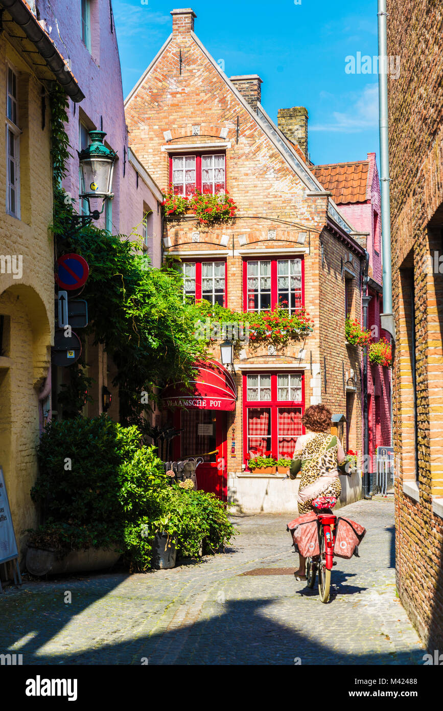 Bruges, Belgio - 1 Settembre 2017: Street con una donna in bicicletta nella città medievale di Bruges, Belgio Foto Stock