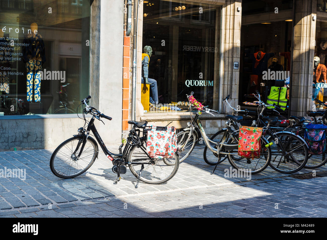 Bruges, Belgio - 1 Settembre 2017: Street con le biciclette parcheggiate davanti a un negozio di quorum nella città medievale di Bruges, Belgio Foto Stock