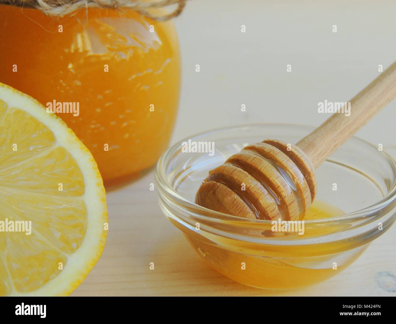 Miele e limone sul bianco sullo sfondo di legno. Un sano concetto, sfondo. Foto Stock
