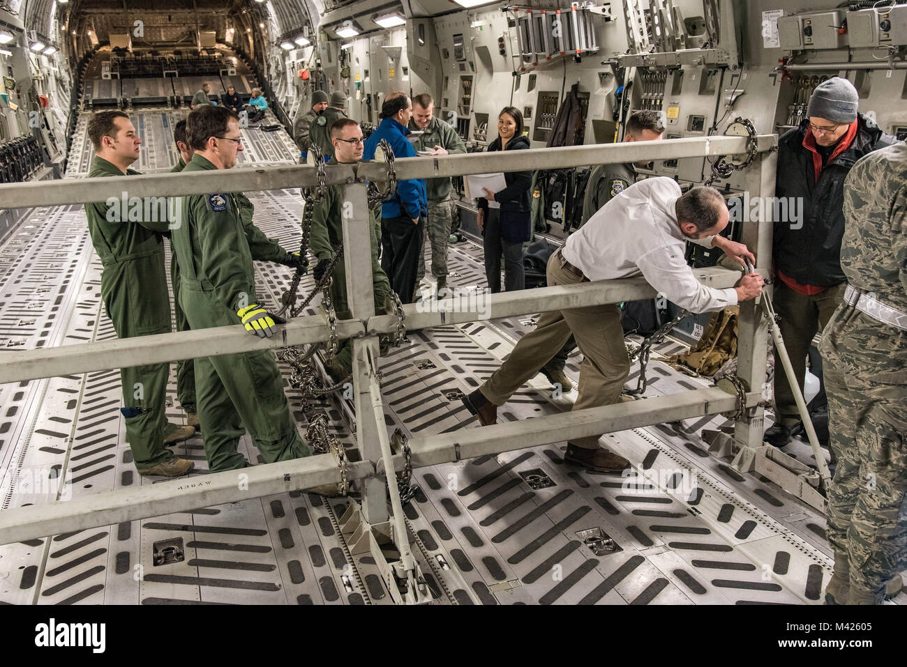 Justin Smoak, Samson corda application engineering manager, Ferndale, nello Stato di Washington, luoghi di una catena sintetica nell'interfaccia scanalato sulla C-17 Globemaster III buffer gruppo di arresto, Gennaio 30, 2018 Alla Dover Air Force Base, Del. il buffer gruppo di arresto è un dispositivo utilizzato durante specifici C-17 Globemaster III airdrop missioni per mantenere pallet dalla marcia in avanti nel vano di carico. (U.S. Air Force Foto di Roland Balik) Foto Stock