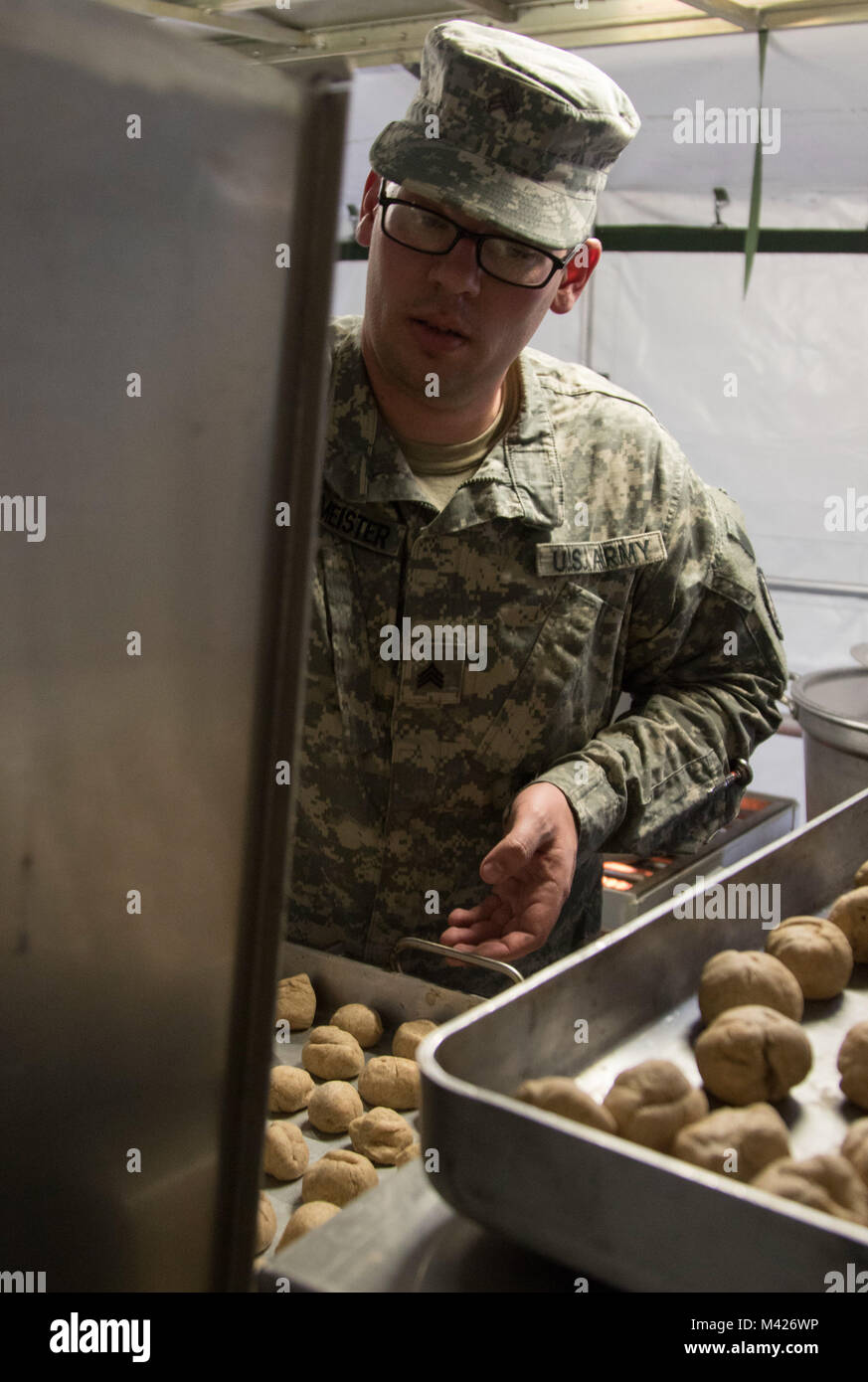 Sgt. Eric Burmeister, U.S. Esercito soldato di riserva dal 530th Polizia Militare battaglione, sotto il duecentesimo MP il comando, luoghi pane in un forno di campo all'interno di un mobile cucina tenda Febbraio 3, 2018 in Camp Ashland, Nebraska. Il 530th MP Bn. sono uno dei quattro finalisti in rappresentanza di Stati Uniti La riserva di esercito di competere nel dipartimento dell'esercito di Philip A. Connelly Awards Program per eccellenza dell'esercito in servizio alimentare la concorrenza di quest'anno. (U.S. Foto dell'esercito da Sgt. 1. Classe Carlos J. Lazo) Foto Stock