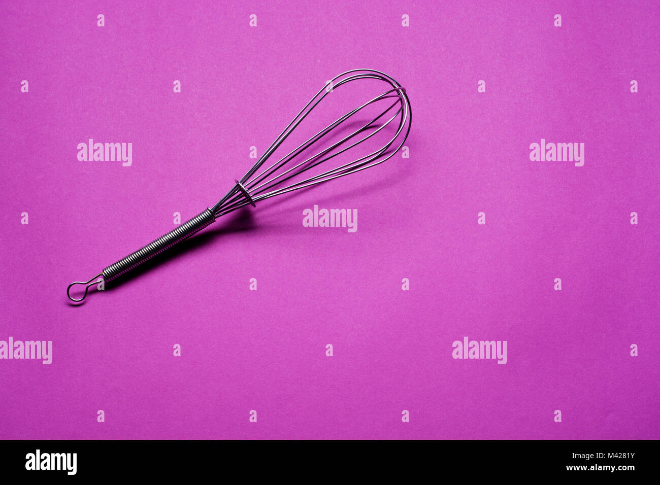 Lavori casalinghi: acciaio frusta su sfondo viola Foto Stock