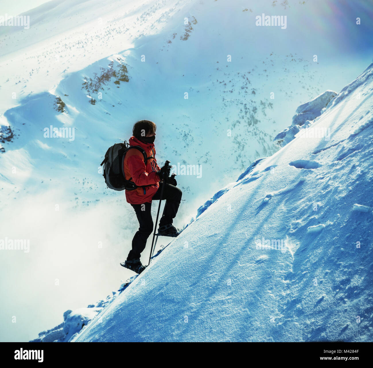 L'uomo con le racchette da neve sui suoi piedi si erge verso l'alto. Uomo con le racchette da neve sul percorso di neve. Uomo in racchette da neve con bastoncini da trekking è la neve al monte Foto Stock