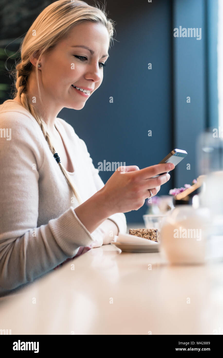Donna che utilizza il suo telefono in una cabina del treno Foto Stock