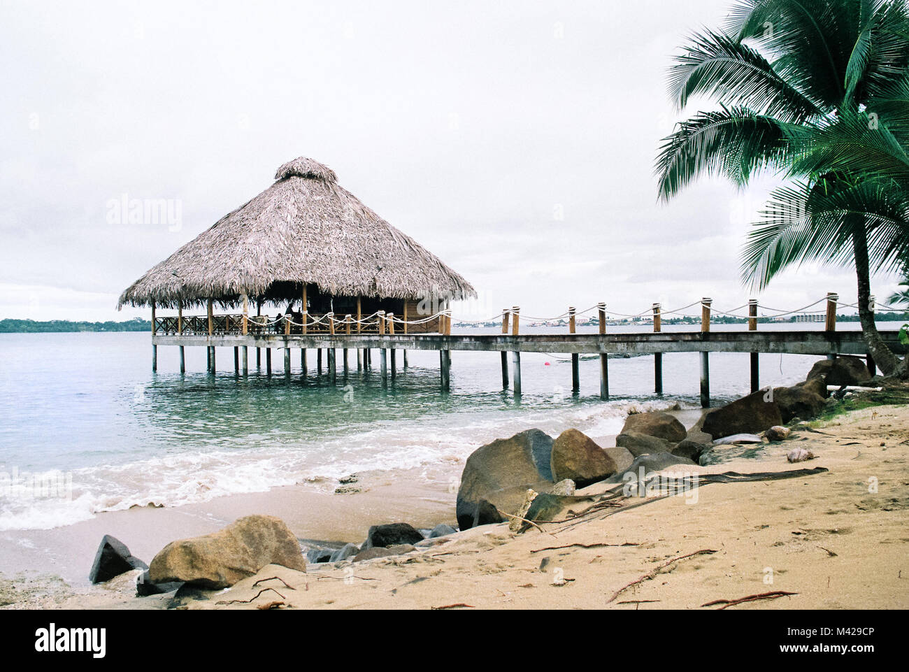 Scena tropicale in Bocas del Toro Panama. Una casa in legno su palafitte vicino alla spiaggia in mare. Foto Stock