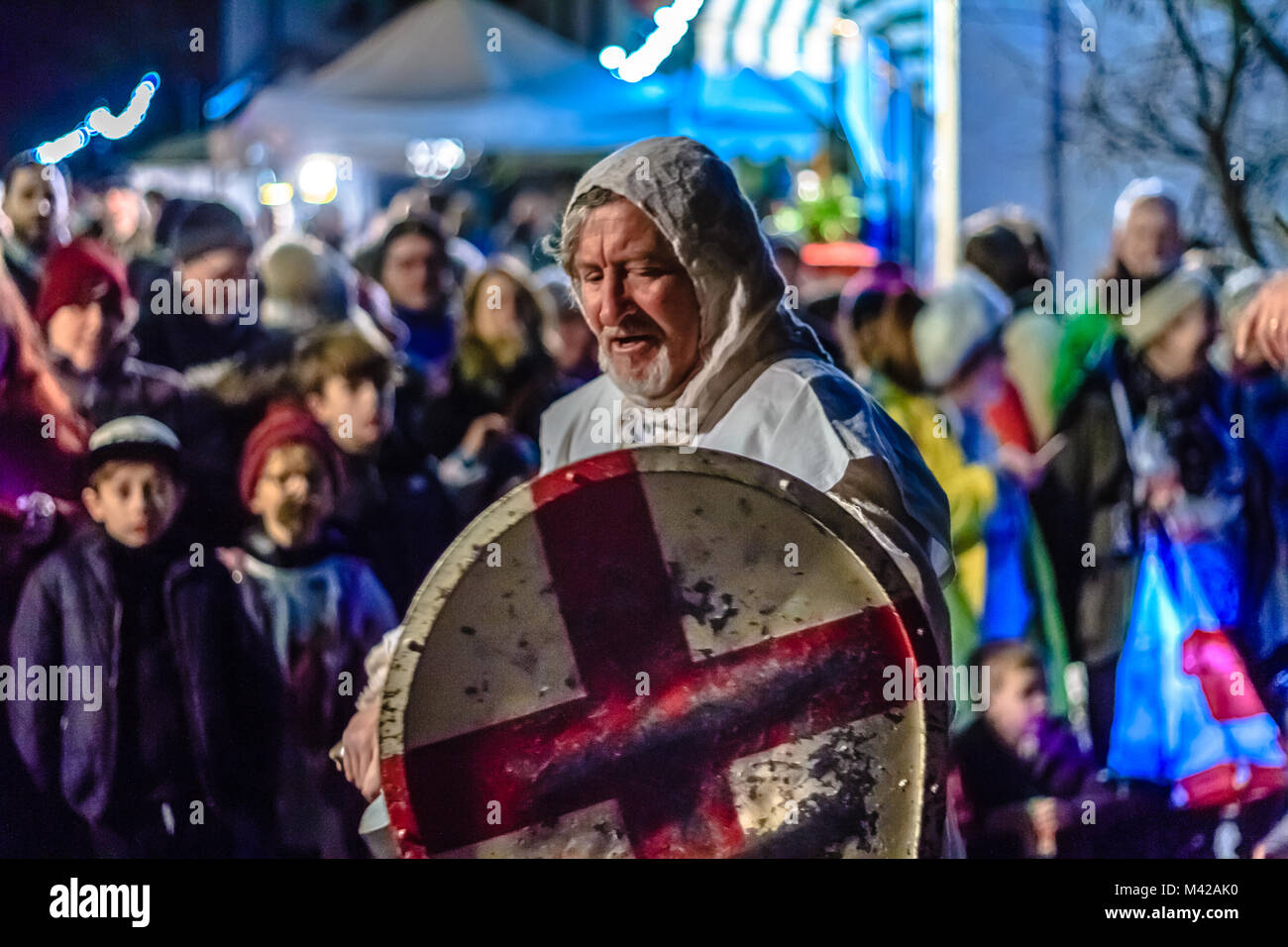 Attori in costume del cavaliere presso il village street festival a guardare la folla, di notte. Wassail festival di apple. Stoke Gabriel, Devon, Regno Unito. Gennaio 2018. Foto Stock