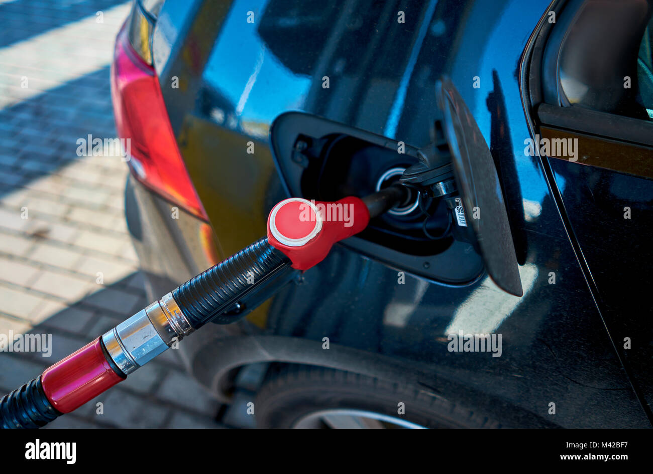 L'uomo riempie la macchina in corrispondenza di una stazione di gas Foto Stock