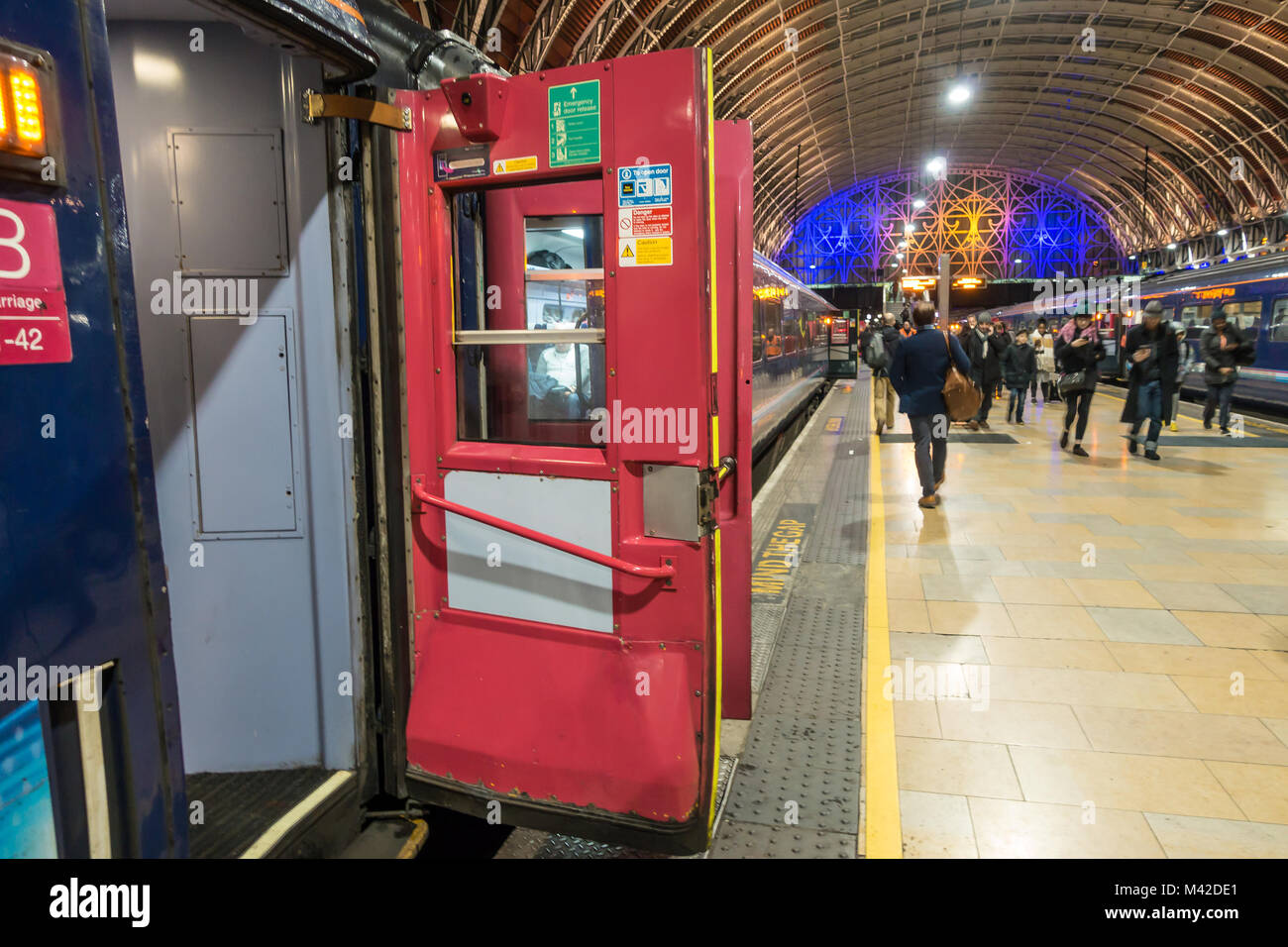 In vecchio stile sbattere le porte aperte su un treno tenendo sui passeggeri imbottitura alla Stazione Ferroviaria di Londra, Regno Unito Foto Stock