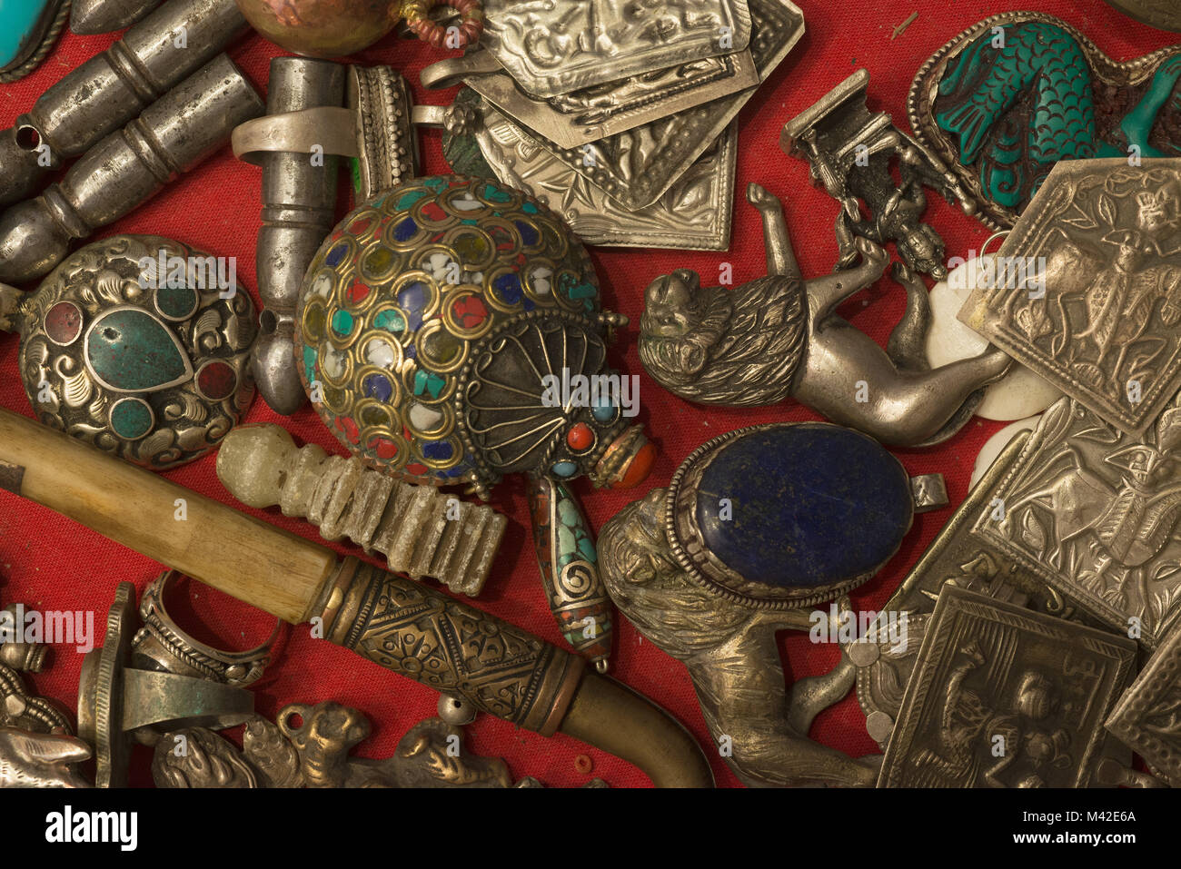 Voci del popolo tibetano culto religioso: decorazioni con turchese e coralli, guarnizioni in pietra, un ciondolo con il blu lapislazzuli, figurina di Lion. Foto Stock