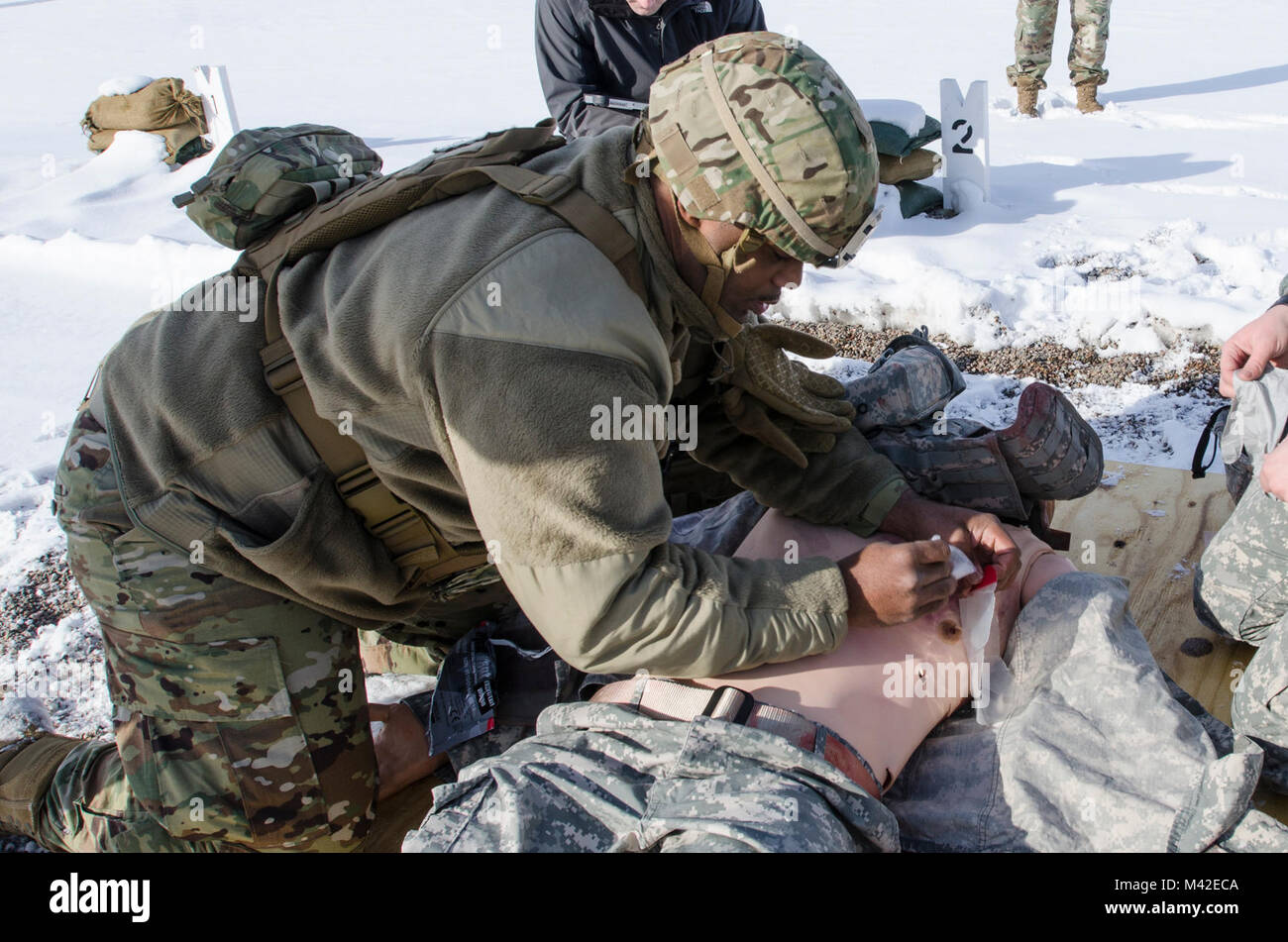 FORT MCCOY, Wis. - STATI UNITI Esercito personale di riserva Sgt. Javar Manley, medic, Task Force Triad, funzionamento freddo acciaio II, considera un torace aspirante avvolto su di un'emergenza simulatore paziente durante una evacuazione medica prova a Fort McCoy, Wis., Febbraio 8, 2018. Funzionamento a freddo è di acciaio negli Stati Uniti La riserva di esercito di equipaggio è servita la qualifica di armi ed esercizio di convalida per garantire America's Army unità di riserva e soldati sono addestrati e pronti per il deployment su breve preavviso come parte della forza di pronto X e portare la lotta contro-ready e letale di armi da fuoco a sostegno dell'esercito e ai nostri partner in tutto il mondo. (U.S. Ar Foto Stock