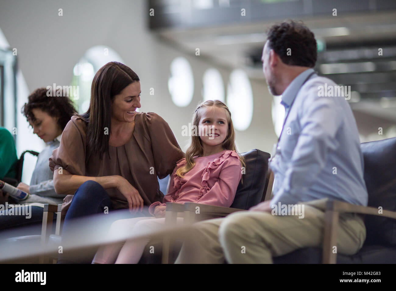 La madre e il bambino a parlare con il medico in sala d'attesa Foto Stock