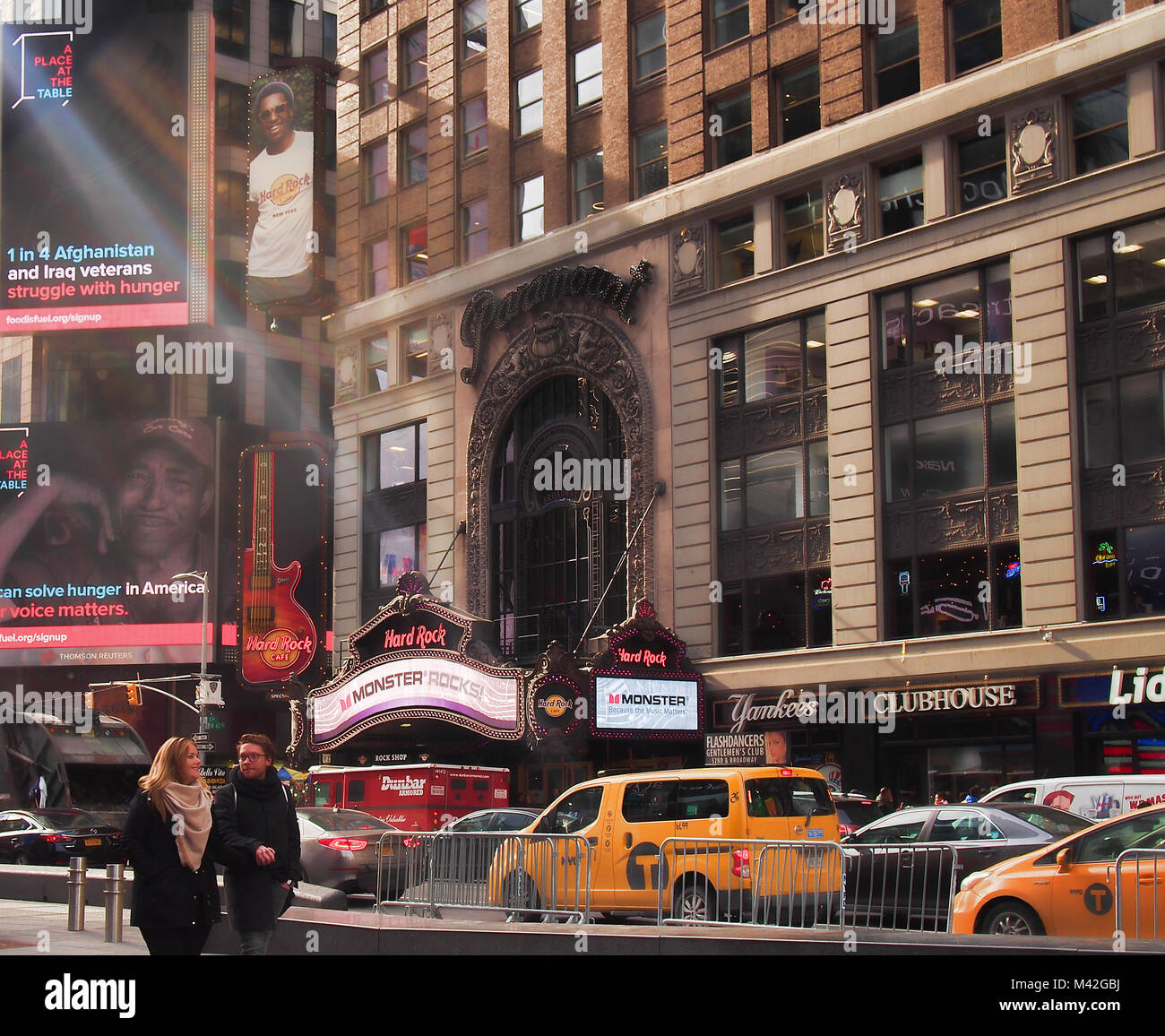 New York , New York, Stati Uniti d'America. Febbraio 1, 2018. Coppia felice a piedi attraverso Times Square nel centro cittadino di Manhattan in inverno con la Paramount edificio in Foto Stock
