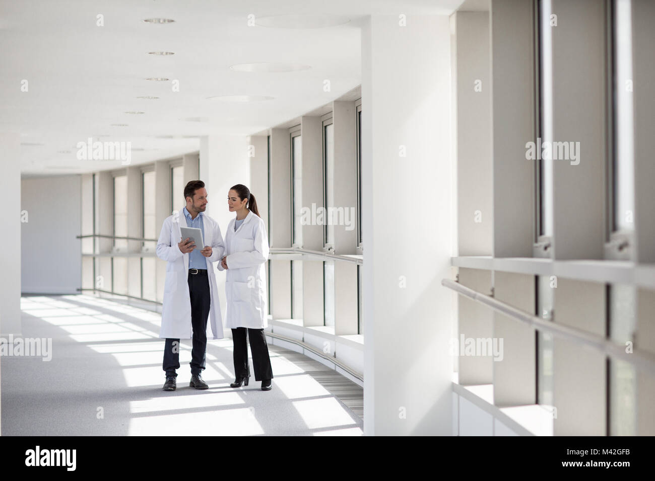 Due professionisti medici discutere i risultati sulla tavoletta digitale Foto Stock