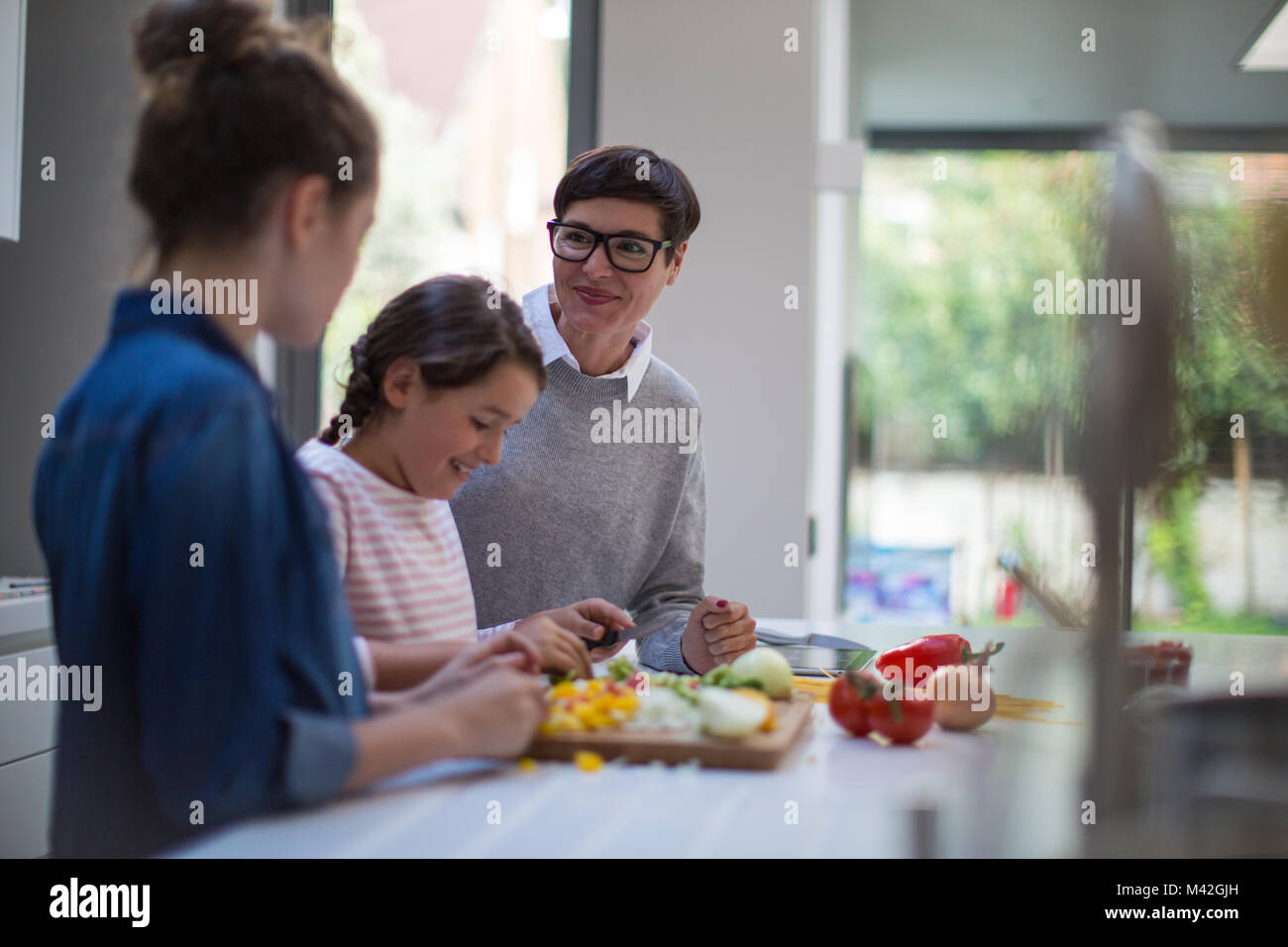 Mamma insegnando le figlie di una ricetta Foto Stock