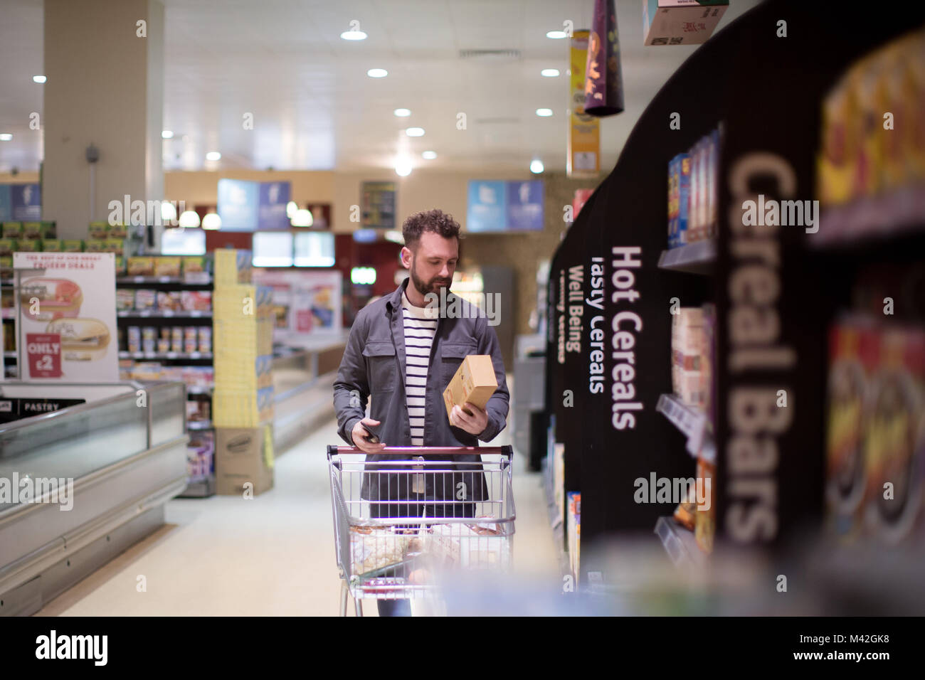Uomo che fa del settimanale di negozio di alimentari Foto Stock