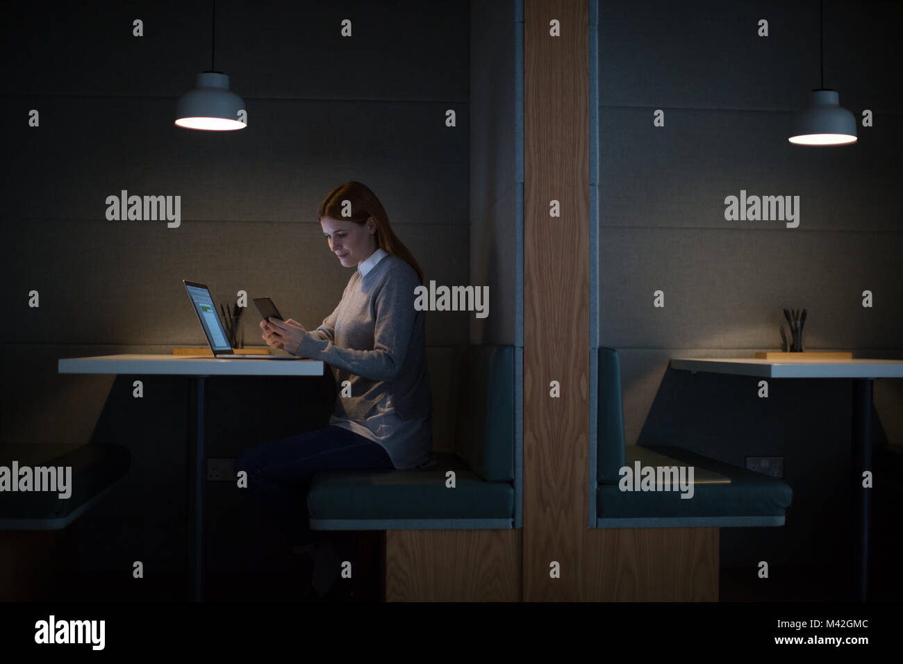 Imprenditrice a lavorare fino a tarda notte in ufficio da solo Foto Stock