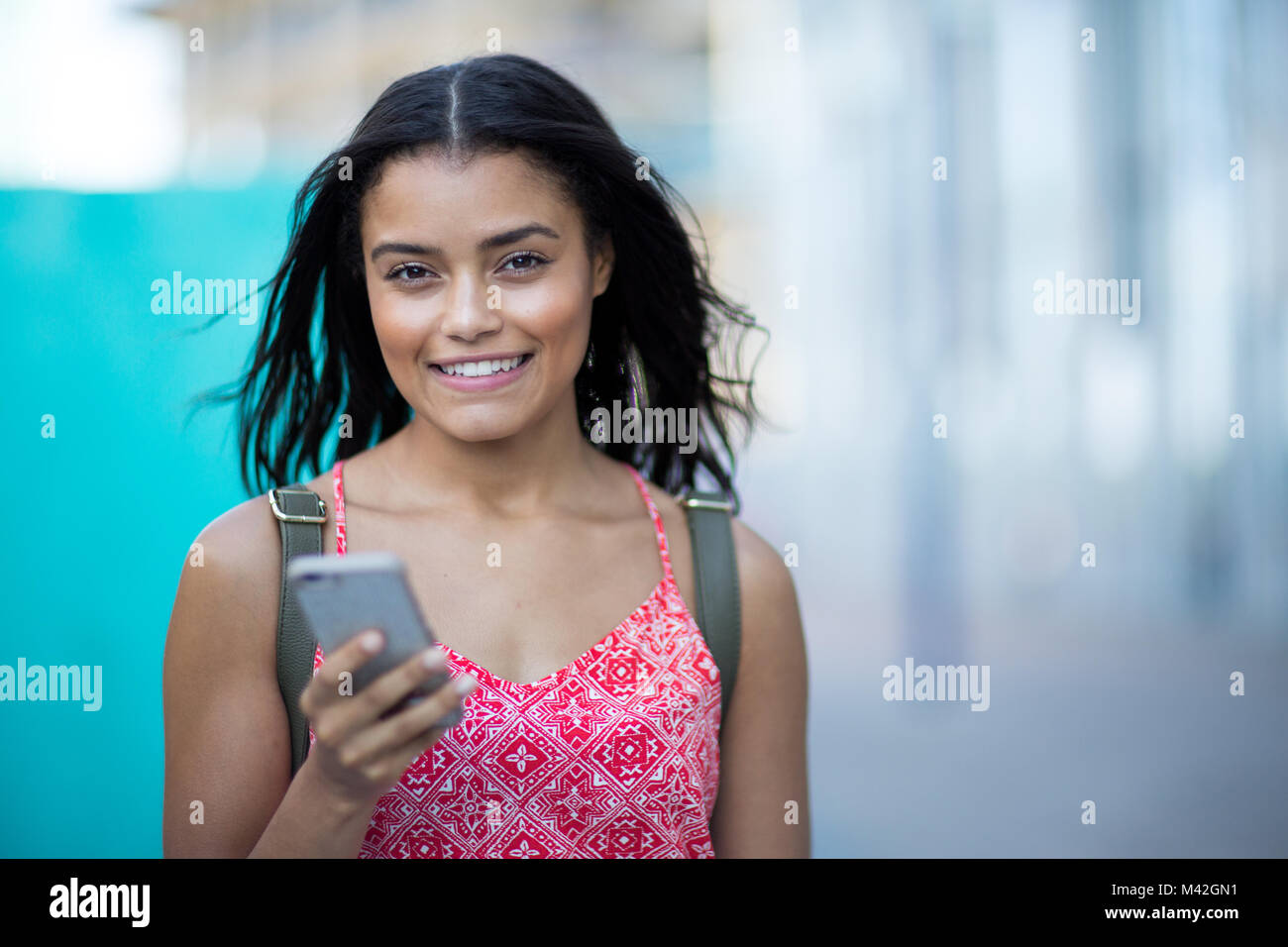 Ritratto di giovane adulto pendolarismo e utilizza lo smartphone Foto Stock