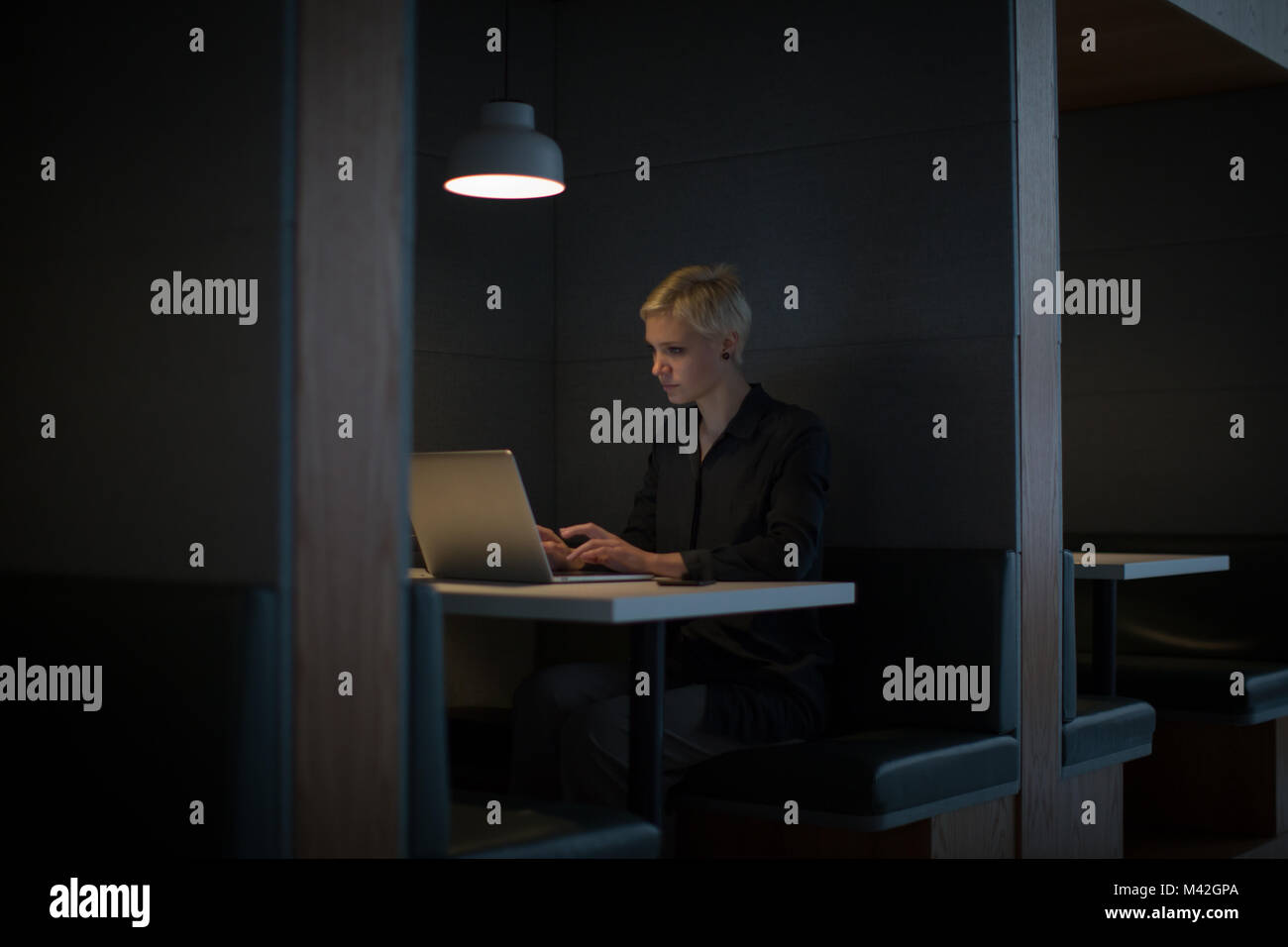 Imprenditrice a lavorare fino a tarda notte in ufficio da solo Foto Stock