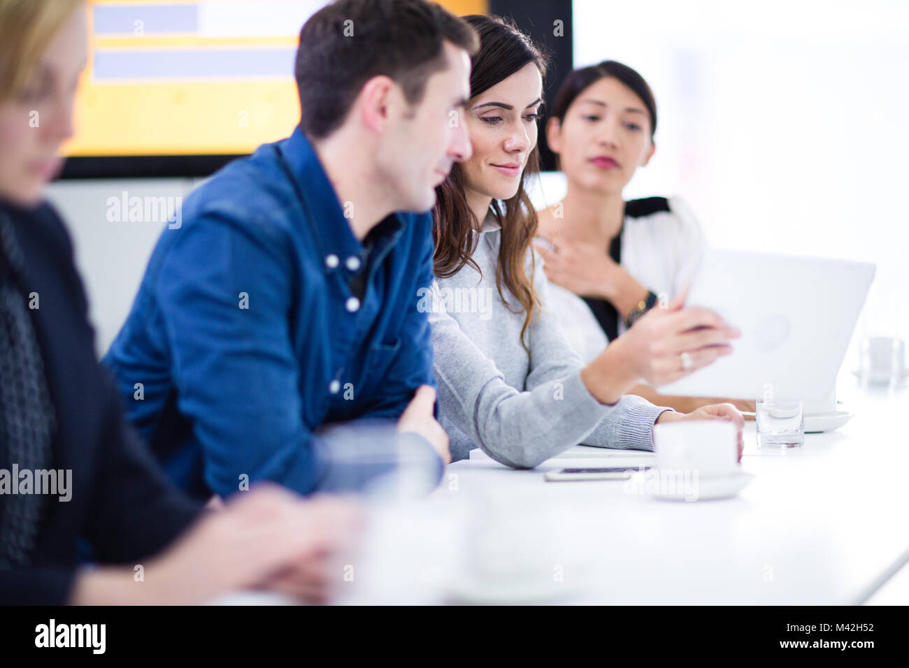 I colleghi in un incontro di lavoro utilizzando la tecnologia Foto Stock