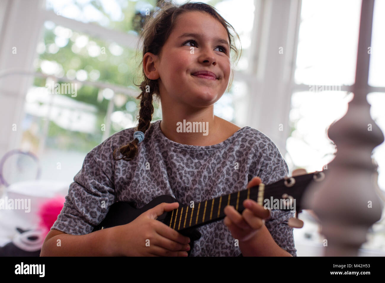 Ragazza che gioca un ukulele Foto Stock