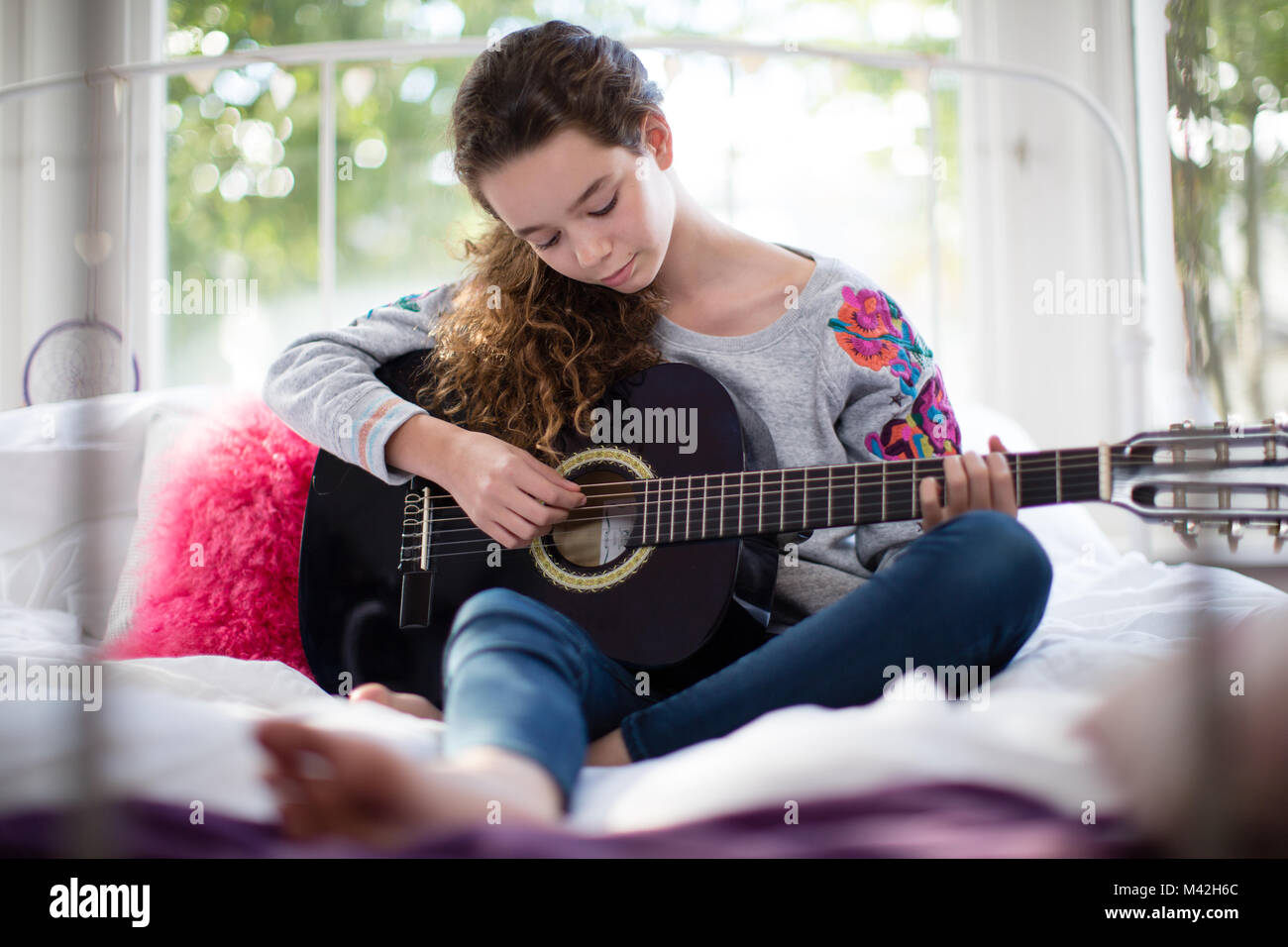 Adolescente suonare la chitarra acustica Foto Stock