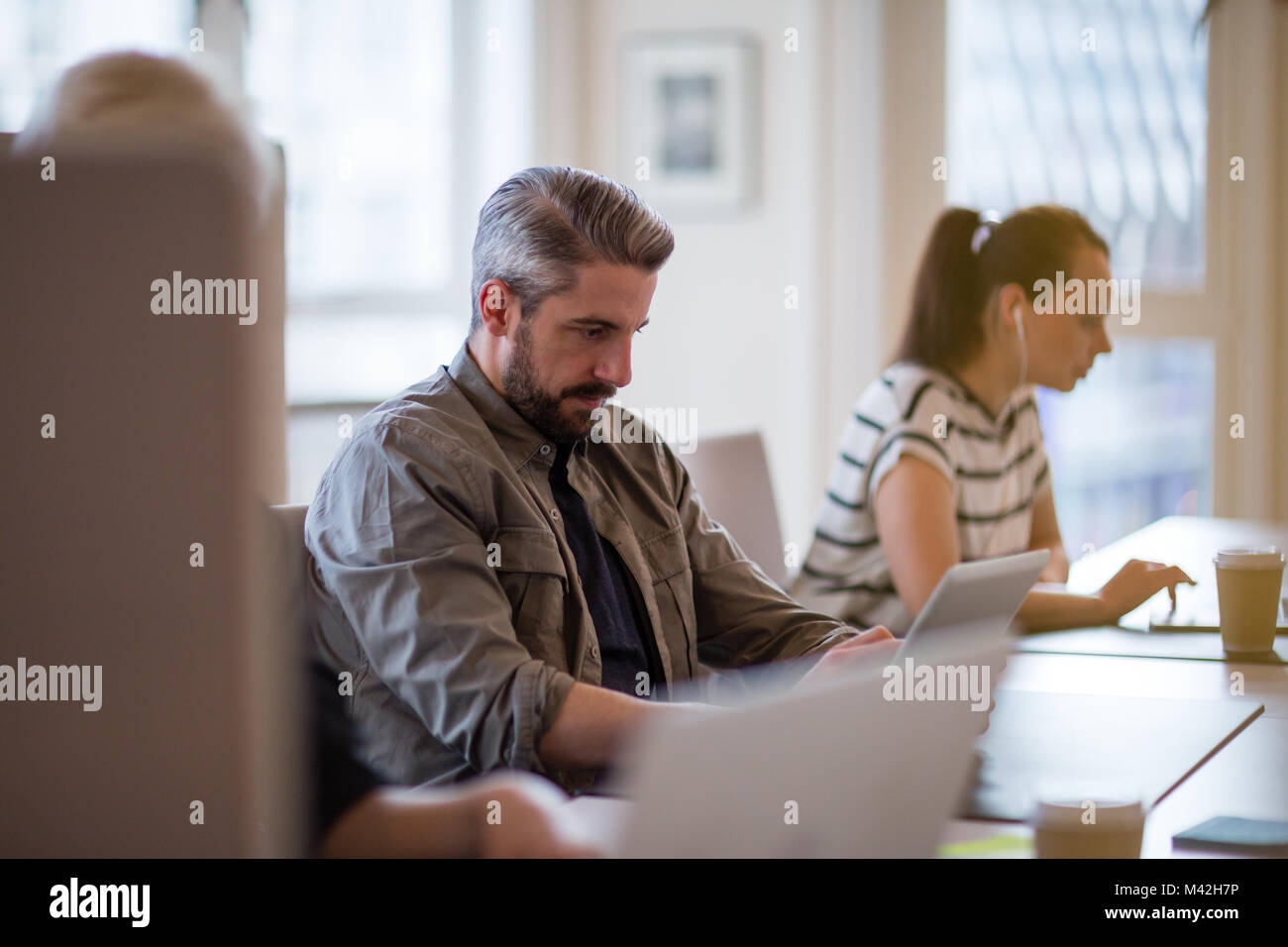 I freelance che lavora in un ufficio condiviso deskspace Foto Stock