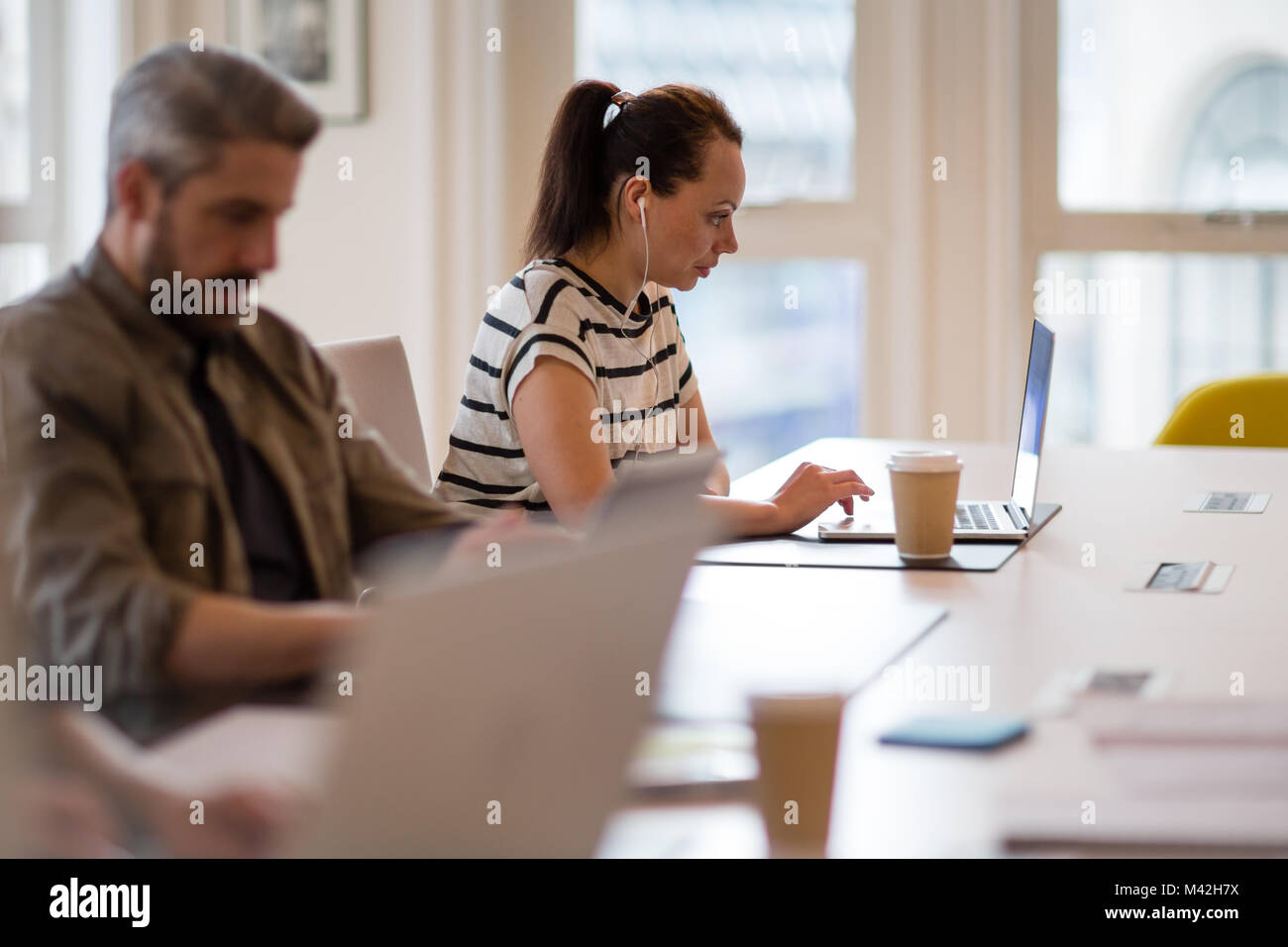 I freelance che lavora in un ufficio condiviso deskspace Foto Stock