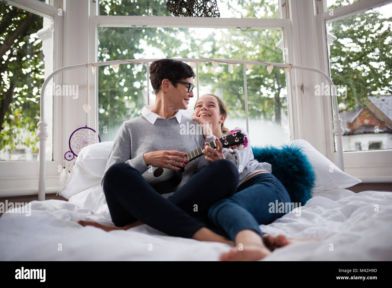La mamma con la figlia giocando ukulele Foto Stock