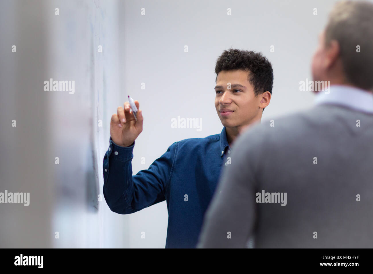 Studente presso una lavagna con penna Foto Stock