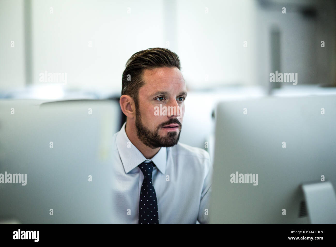 Imprenditore utilizzando il computer in ufficio vuoto Foto Stock