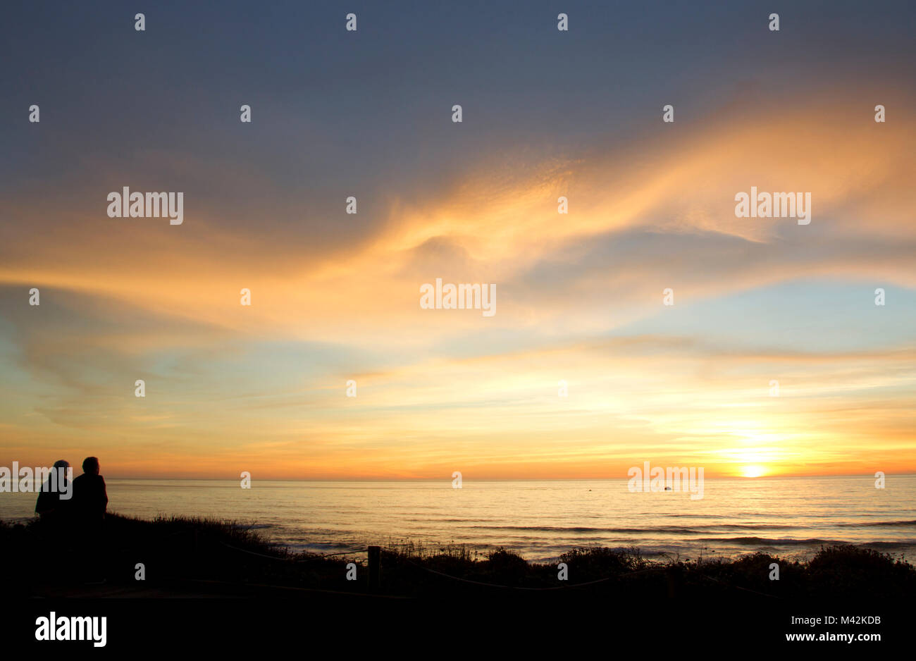 Stagliano l uomo e la donna a guardare il tramonto del Pacifico Foto Stock