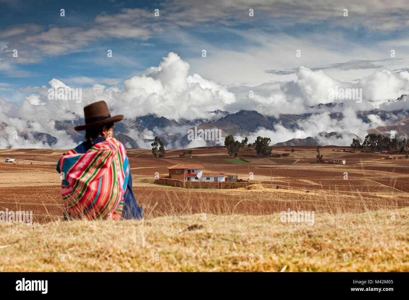 Il Perù, Chinchero, agricoltore e la donna indiana, nella parte anteriore del snowcovered montagne delle Ande. Foto Stock