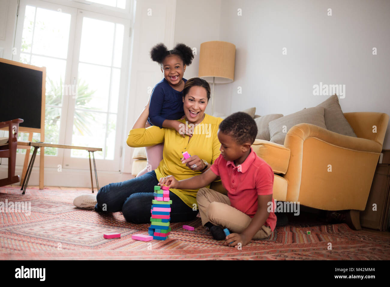 La mamma con i bambini a costruire una torre Foto Stock