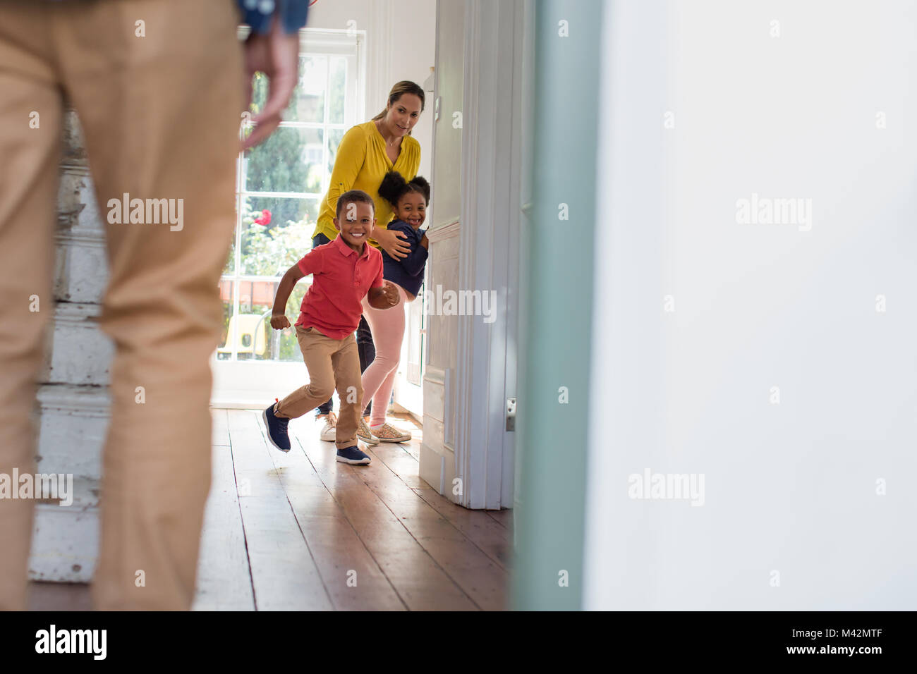 Bambini running di dare il benvenuto a papà home Foto Stock