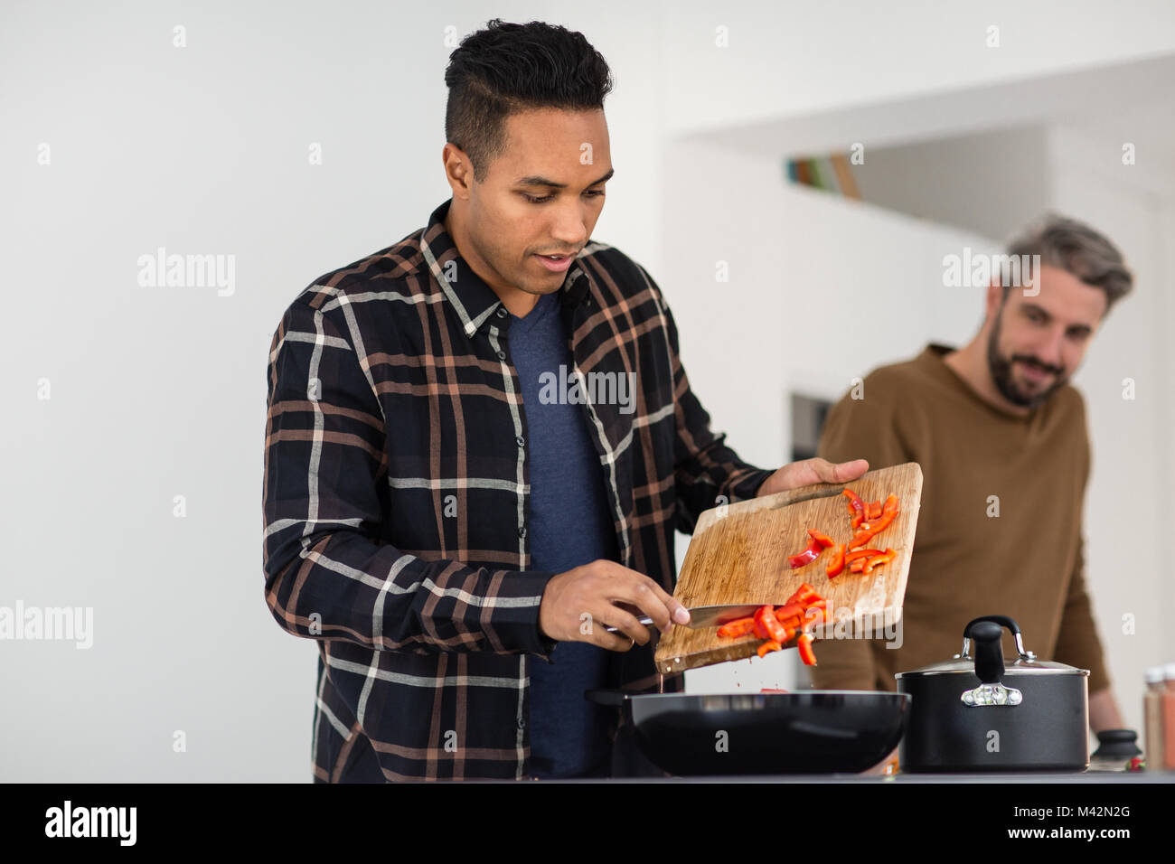 Maschio adulto di mettere gli ingredienti in una teglia Foto Stock