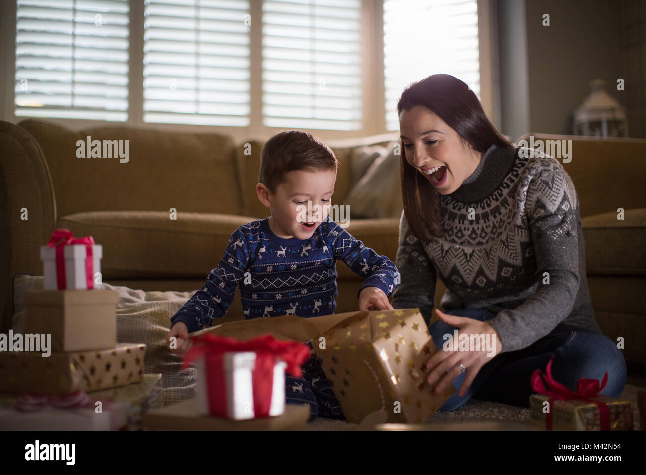 Madre e Figlio di unwrapping regali di Natale Foto Stock