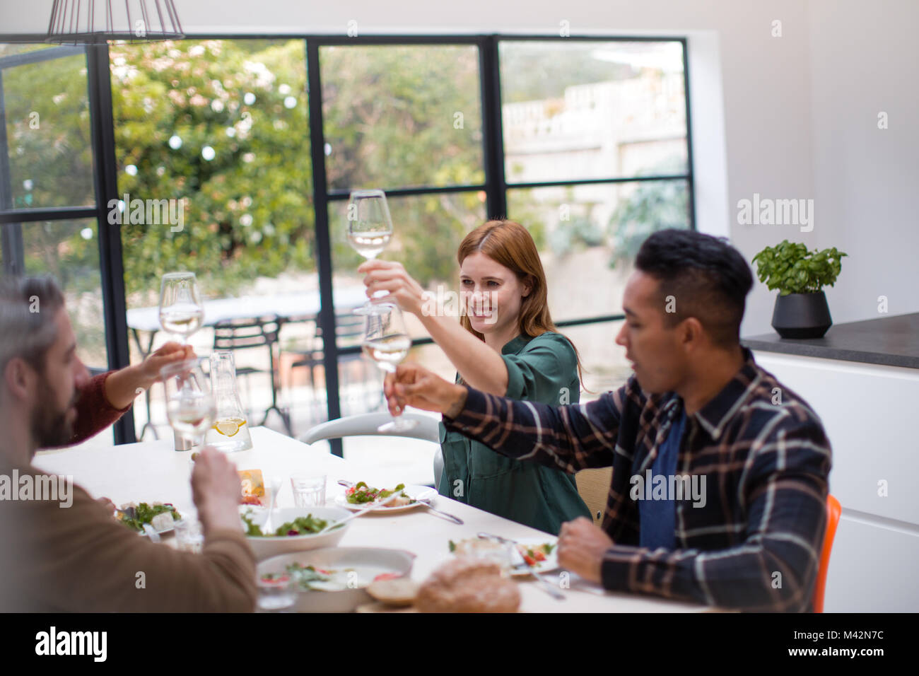 Amici bicchieri tintinnanti nel corso di un pasto insieme Foto Stock