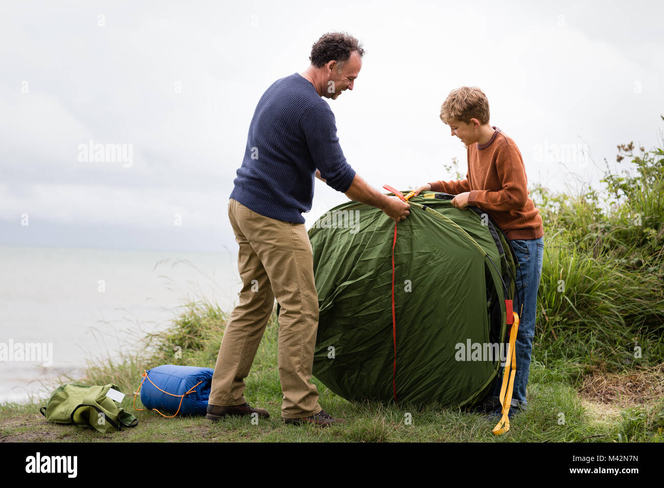 Padre e Figlio di mettere una tenda insieme Foto Stock