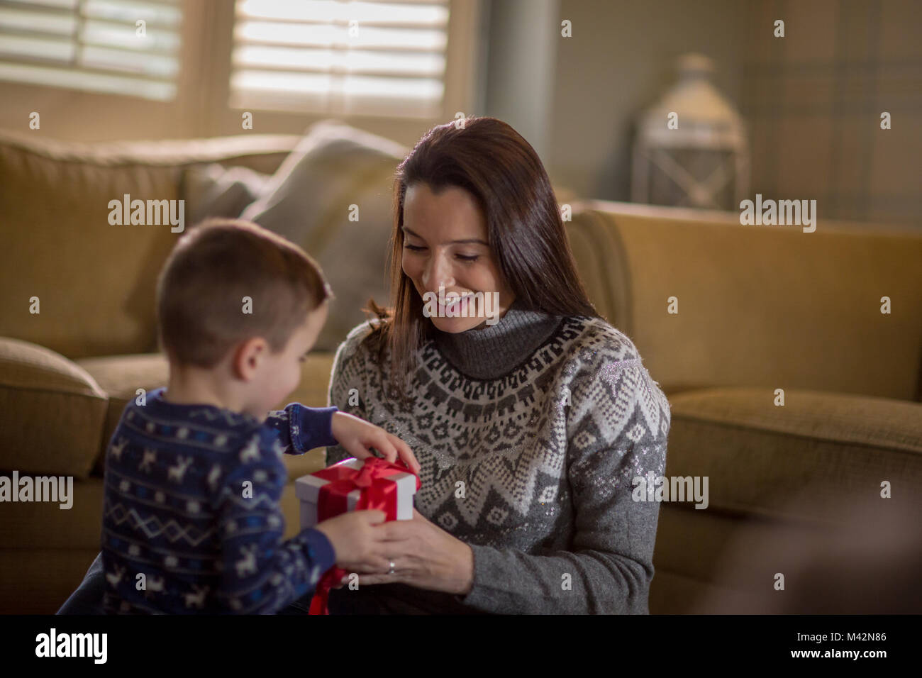 Madre e Figlio di unwrapping regali di Natale Foto Stock