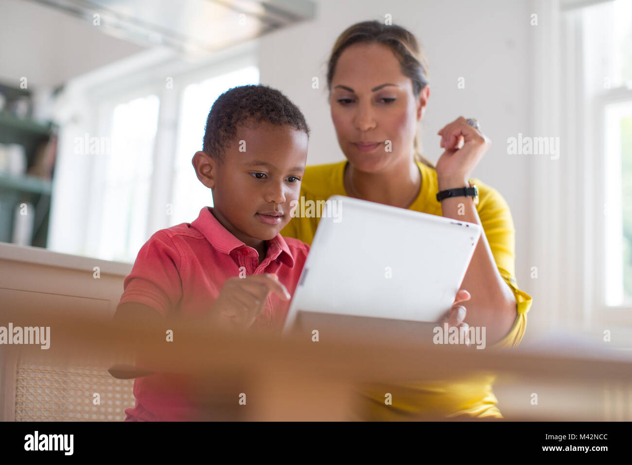 Madre figlio di insegnamento come utilizzare la tavoletta digitale Foto Stock