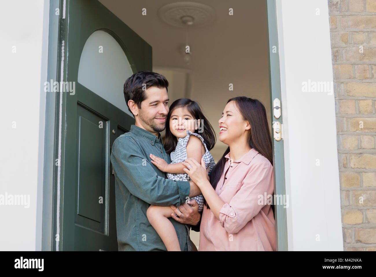 Famiglia in piedi nella porta di casa Foto Stock