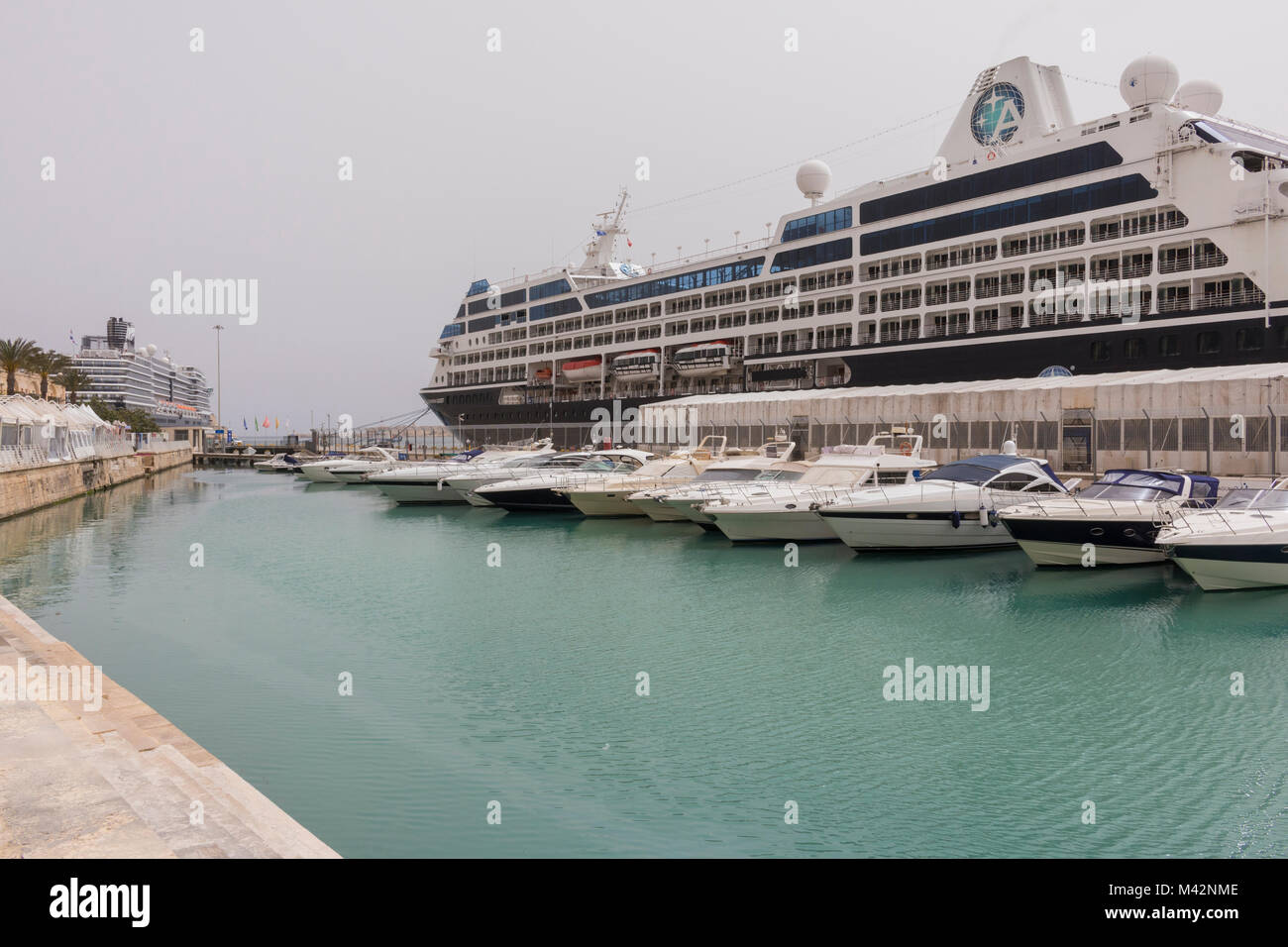 Una immagine di una nave da crociera ormeggiata al Porto di La Valletta, Malta con diverse velocità di piccole barche ormeggiate accanto a. Foto Stock