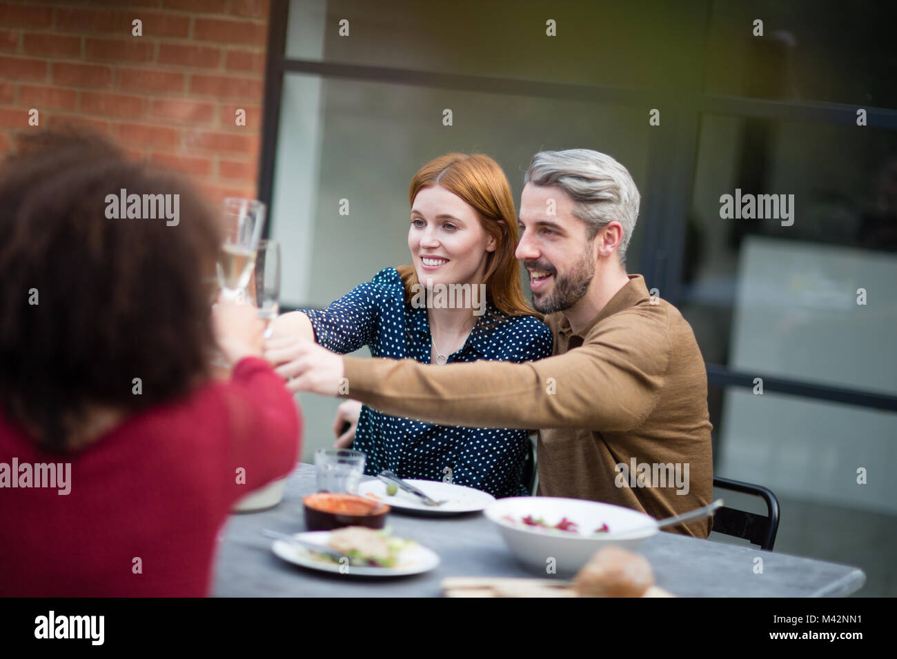 Gli amici di mangiare un pasto all'aperto Foto Stock